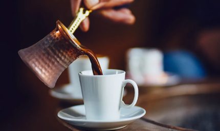 Café café colombiano siendo servido en una taza blanca, resaltando la calidad del café natural de origen colombiano de Café Raizal.