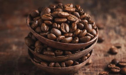 Granos de café colombianos en tazas de madera, resaltando su calidad y origen natural.