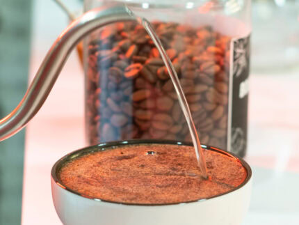 Cafes raizal, café colombiano de origen natural preparado en una taza con agua caliente, café en grano en una jarra cerca, café de calidad para los amantes del café colombiano auténtico y de origen bajo método natural.